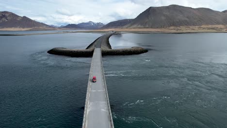 Car-driving-over-Long-bridge-in-Iceland-shaped-like-sword