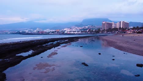 Toma-De-Drones-De-Playa-Las-Americas-Beach-Resort-Edificios-Vista-Turística-De-Fondo,-Santa-Cruz-Tenerife-Ciudad-Capital-En-España