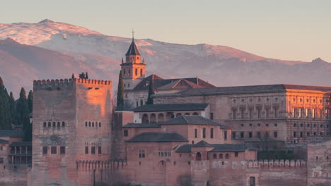 Zoom-view-of-Alhambra-and-Snowy-Sierra-Nevada-day-to-night-time-lapse-in-Granada,-Andalusia,-Spain