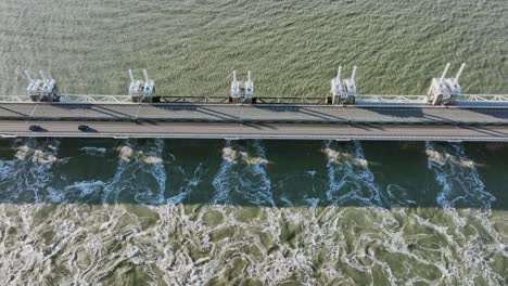 Aerial-overhead-shot-of-opened-sluices-on-the-Eastern-Scheldt-storm-surge-barrier-in-Zeeland,-the-Netherlands,-on-a-sunny-day