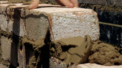 CLOSE-UP,-Brick-Placed-On-Even-Wet-Mortar-Cement-During-House-Construction