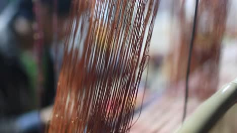 Close-up-shot-of-yarn-which-is-used-for-weaving-by-the-man-working-with-the-handmade-weaving-threads-in-Sri-Lanka