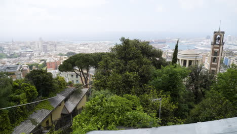 Green-vibrant-trees-and-majestic-cityscape-of-Genoa-in-background,-pan-left-view