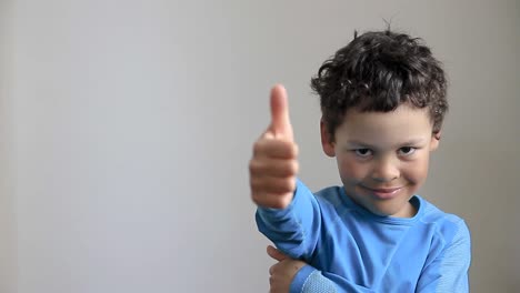 boy-showing-thumbs-up-gesture-on-white-grey-background-stock-video
