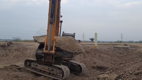 Excavator-is-lifting-big-clay-stone-while-digging-a-basement-on-construction-site-in-India