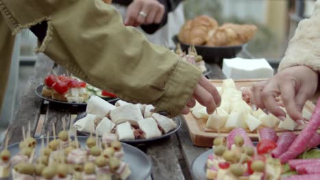 Slow-motion-shot-of-a-wooden-dinner-table-filled-with-party-snacks-and-croissants