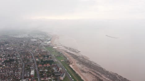 Drone-shot-over-small-english-seaside-village-cloudy-day