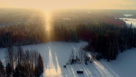 Luftaufnahme-Einer-Winterlich-Verschneiten-Waldlandschaft-Bei-Sonnenaufgang-Mit-Kleinen-Containerhäusern-Isoliert-In-Einem-Ruhigen-Wald