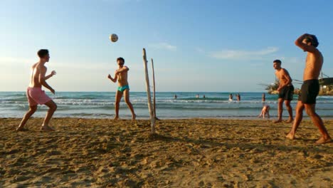 Real-people-have-fun-enjoying-playing-football-on-sandy-beach-in-Italy