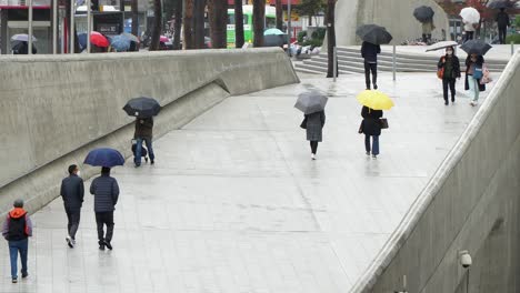 People-With-Umbrella-Walking-On-A-Rainy-Day-At-Dongdaemoon-Design-Plaza-In-Seoul,-South-Korea