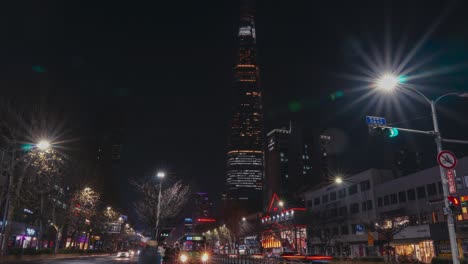 Zoom-out-timelapse-from-Lotte-World-Tower-to-people-boarding-buses-at-bus-stop-at-night