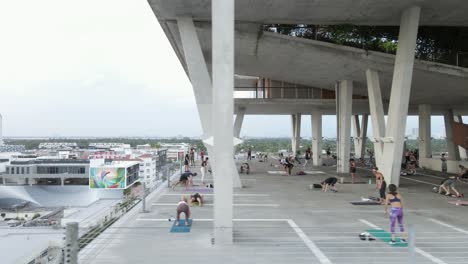 Aerial:-Tae-Bo-exercise-class-in-parking-garage-over-Alton-Rd,-Miami