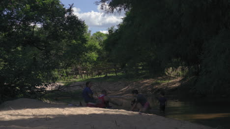 Family-enjoying-public-river-beach,-Paraguay