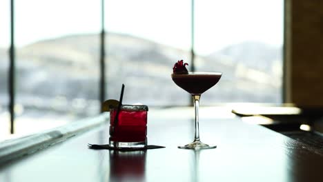 Gläser-Cocktail-Und-Likör-Auf-Dem-Tisch-Mit-Klarem-Glasfenster-Im-Verschwommenen-Hintergrund