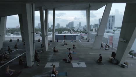 Aerial-flyby:-Yoga-easy-pose-in-social-distance-class-in-Miami-parkade