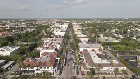 Aerial-follows-quiet-palm-lined-Fifth-Ave-in-sunny-Naples,-Florida