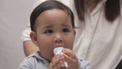 Cute-Baby-Boy-With-Chubby-Cheeks-Playing-With-White-Plastic-Bottle