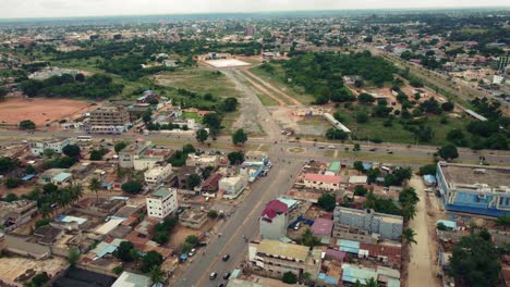 Vista-Aérea-Circular-Cinematográfica-De-Las-Carreteras-De-Barrio-De-La-Ciudad-Africana-Con-Tráfico,-Lomé,-áfrica-Occidental
