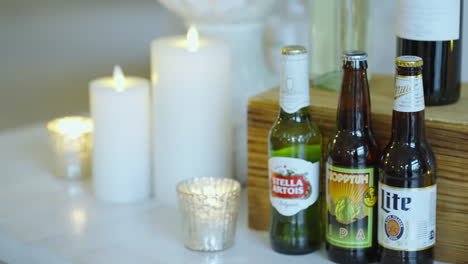 Choice-of-alcoholic-beers-on-table-beside-candles,-Wedding