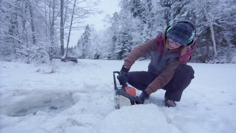 HANDHELD---woman-using-a-chainsaw-dramatically-cuts-an-ice-hole