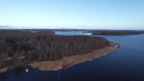 Drone-Flyover-Beautiful-Lake-Surrounded-By-Forest,-Drone-Over-Treetops---Dolly-In-Shot