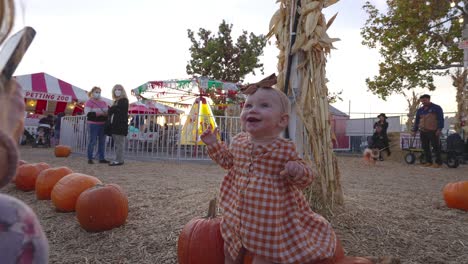 Happy-Baby-girl-sitting-on-a-pumpkin-for-the-first-time-at-pumpkin-patch