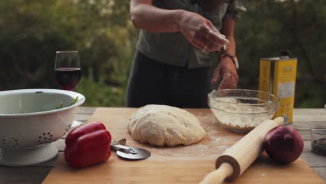 Slow-motion-shot-of-dough-being-prepared-outside-to-make-a-homemade-pizza