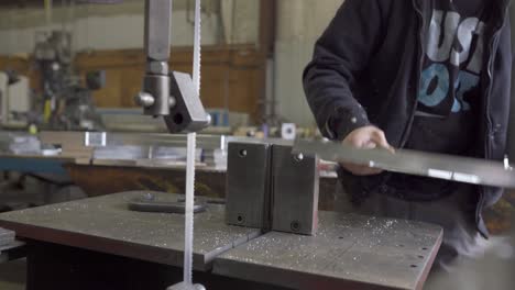 Metalworker-Removing-Clamps-After-Cutting-Aluminum-On-A-Bandsaw