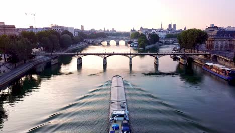 Cargo-ship-floating-on-calm-morning-Seine-river-and-heading-to-Pont-des-Arts