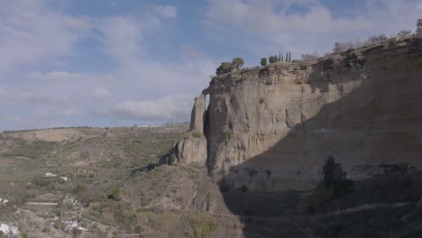 Aerial-approaches-nearly-detached-limestone-pillar-below-Ronda,-Spain