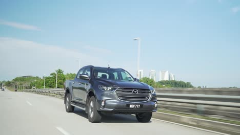 Malaysia,-10.-April-2022:-Mazda-Bt-50-Holt-Den-Lkw-Ab,-Der-Schnell-Auf-Der-Mautstraße-Fährt