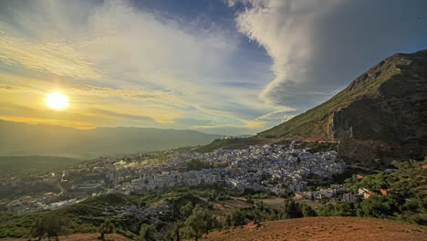 Time-lapse-shot-of-beautiful-golden-sunset-over-ancient-city-of-Chefchaoen-in-Africa---Panorama-view-of-lighting-town-between-mountains