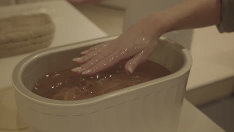 Scented-Paraffin-Hand-Wrap-Treatment-in-Wellness-Spa-Center,-Close-Up-of-Female-Hand-in-Hot-Wax,-Slow-Motion