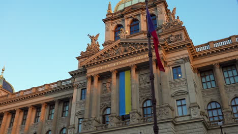 Ukrainische-Flagge-An-Der-Fassade-Des-Prager-Nationalmuseums,-Tschechische-Flagge-An-Der-Stange