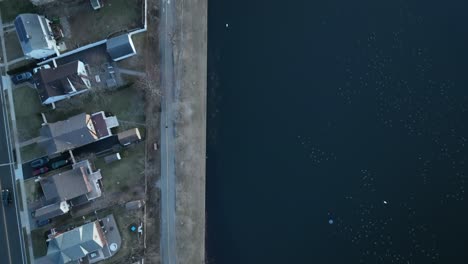 An-aerial-shot-directly-over-a-green-pond-in-a-suburban-neighborhood-on-Long-Island,-NY