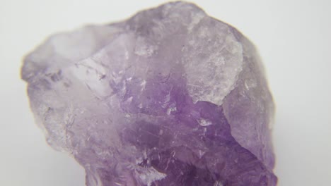 Un-Cristal-De-Amatista-Púrpura-Cortado-En-Bruto,-Primer-Plano-Sobre-Fondo-Blanco