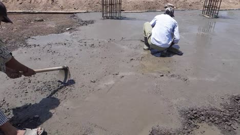 A-worker-Leveling-PCC-Foundation-Concrete-slab-On-A-New-Building-Construction-Site