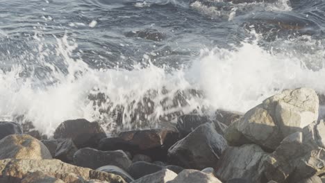 Ocean-waves-break-on-big-stone-blocks-in-slowmotion-and-4K-at-25fps
