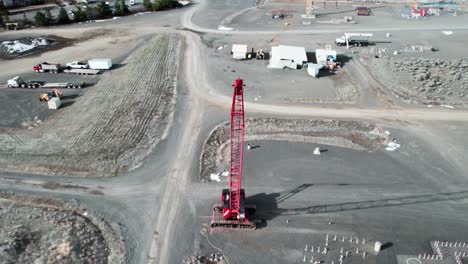 Top-down-aerial-view-of-a-lattice-boom-crawler-crane-at-a-construction-site,-dolly-zoom-effect