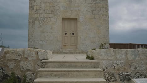 Tiro-De-Abajo-Hacia-Arriba-De-Una-Hermosa-Iglesia-De-Piedra-Rural-En-El-Campo,-Malta