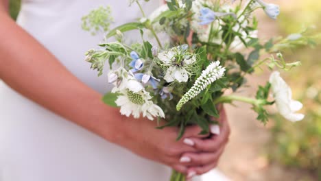 Close-Up-of-Bridesmaid-Holding-Small-Wildflower-Wedding-Bouquet-in-Her-Hands-Outdoors-1080p-60fps