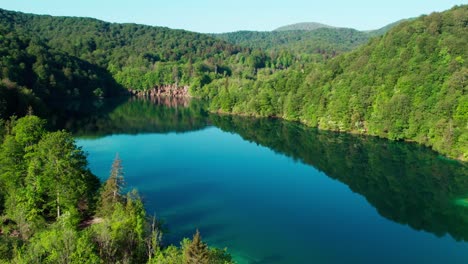 Luftaufnahme-Des-Ruhigen-Sees,-Des-Grünen-Waldes-Und-Des-Wasserfalls-Im-Sommer