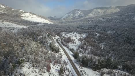 drone-view-of-a-completely-snowy-valley-that-is-crossed-by-a-road