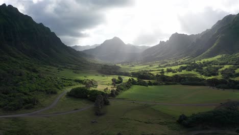 Low-aerial-dolly-shot-of-the-iconic-Jurassic-Valley-with-beautiful-sunlight-shining-through-the-clouds-on-the-island-of-O'ahu,-Hawaii