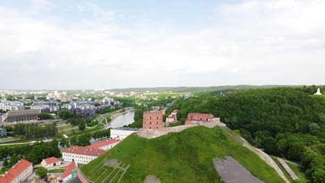 Gediminas-Castle-and-Vilnius-township,-aerial-ascend-reveal-shot