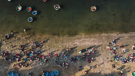 Aerial-top-down,-Vietnamese-fishing-villagers-crowded-on-beach-shore
