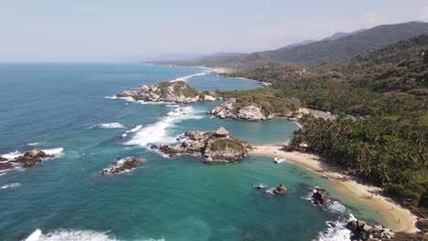 4K-Aerial-pan-shot-of-sea-and-rock-tropical-Tayrona-Park-cabo-san-juan-Colombia
