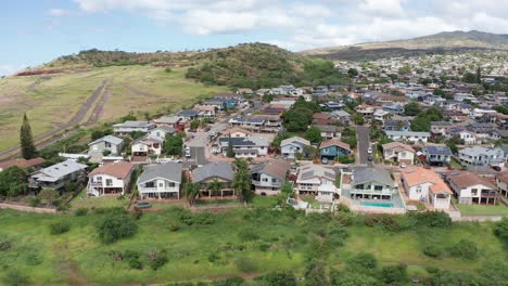 Reverse-pullback-aerial-shot-of-houses-on-a-mountainside-in-Kapolei-on-the-island-of-O'ahu,-Hawaii