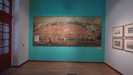 Muñeco-Lento-Hacia-Una-Gran-Pintura-Antigua-De-La-Ciudad-De-México-Colgada-En-La-Pared-Dentro-Del-Museo-De-Los-Cabildos