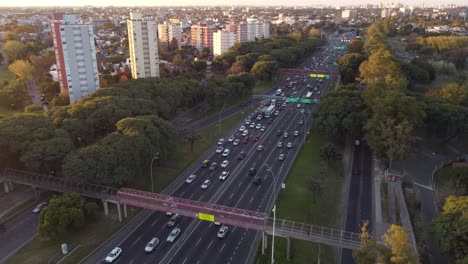circular-drone-view-of-the-heavy-traffic-on-the-General-Paz-Highway-at-sunset-around-Buenos-Aires,-Argentina-in-South-America